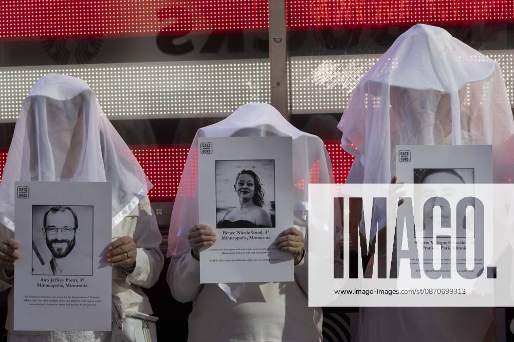 People dressed in white shrouds are Human Beings, memorializing people killed by gun violence from Federal immigration agents by holding signs with the images and names of Alex Jeffrey Pretti Renee Nicole Good Silverio Villegas Gonzalez. Demonstrators with the anti-gun violence organization Gays Against Guns protest under the Times Square US Army Recruiting Station LED American flag to denounce U.S. Immigration and Customs Enforcement (ICE,) President Trump s immigrant detention and mass deportation policies. New York USA - ZUMAr174 20261025_znp_r174_015