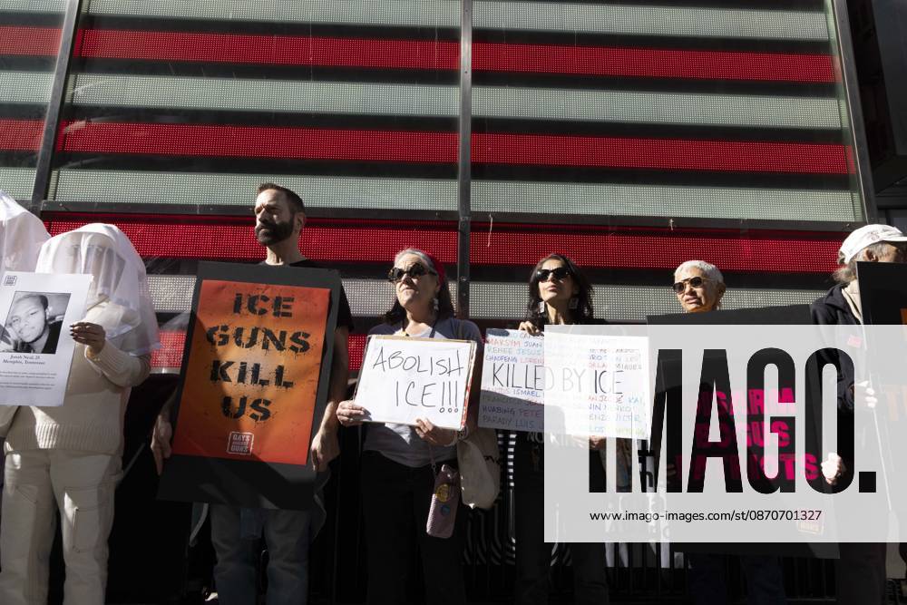 Demonstrators with the anti-gun violence organization Gays Against Guns protest under the Times Square US Army Recruiting Station LED American flag to denounce U.S. Immigration and Customs Enforcement (ICE) and President Trump s immigrant detention and mass deportation policies. Protesters hold signs that read ICE GUNS KILL US ABOLISH ICE!!! KILLED BY ICE. People dressed in white shrouds are Human Beings, memorializing people killed by gun violence from Federal immigration agents by holding signs with their images and names. New York USA - ZUMAr174 20261025_znp_r174_003