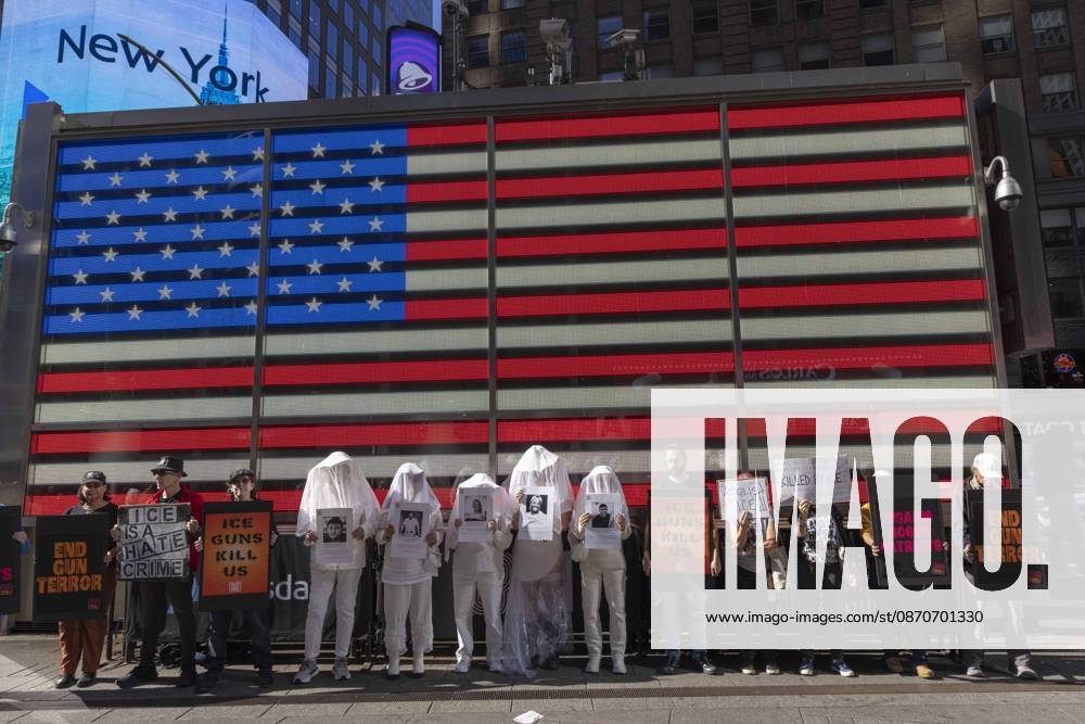 Demonstrators with the anti-gun violence organization Gays Against Guns protest under the Times Square US Army Recruiting Station LED American flag to denounce U.S. Immigration and Customs Enforcement (ICE) and President Trump s immigrant detention and mass deportation policies. Protesters hold signs that read END GUN TERROR ICE IS A HATE CRIME ICE GUNS KILL US DISARM BOGUS PATRIOTS. People dressed in white shrouds are Human Beings, memorializing people killed by gun violence from Federal immigration agents by holding signs with their images and names. New York USA - ZUMAr174 20261025_znp_r174_006