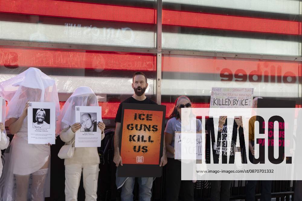 Demonstrators with the anti-gun violence organization Gays Against Guns protest under the Times Square US Army Recruiting Station LED American flag to denounce U.S. Immigration and Customs Enforcement (ICE) and President Trump s immigrant detention and mass deportation policies. Protesters chant holding signs that read ICE GUNS KILL US ABOLISH ICE!!! KILLED BY ICE DISARM BOGUS PATRIOTS. People dressed in white shrouds are Human Beings, memorializing people killed by gun violence from Federal immigration agents by holding signs with their images and names. New York USA - ZUMAr174 20261025_znp_r174_007