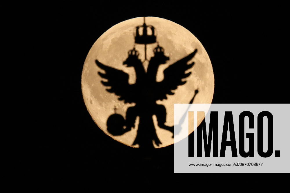 RUSSIA, MOSCOW - OCTOBER 25, 2026: The Russian coat of arms atop a building is silhouetted against the full moon shining over the city Moscow Russia - ZUMAt113 20261025_zaa_t113_334