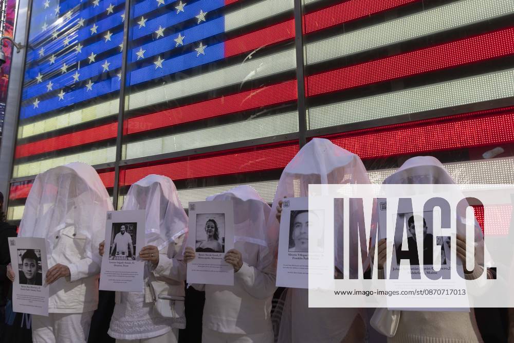 People dressed in white shrouds are Human Beings, memorializing people killed by gun violence from Federal immigration agents by holding signs with the images and names of Ruben Ray Martinez Lorenzo Salgado Araujo Renee Nicole Good Silverio Villegas Gonzalez Johan Sebastian Duran Guerrero. Demonstrators with the anti-gun violence organization Gays Against Guns protest under the Times Square US Army Recruiting Station LED American flag to denounce U.S. Immigration and Customs Enforcement (ICE,) President Trump s immigrant detention and mass deportation policies. New York USA - ZUMAr174 20261025_znp_r174_008