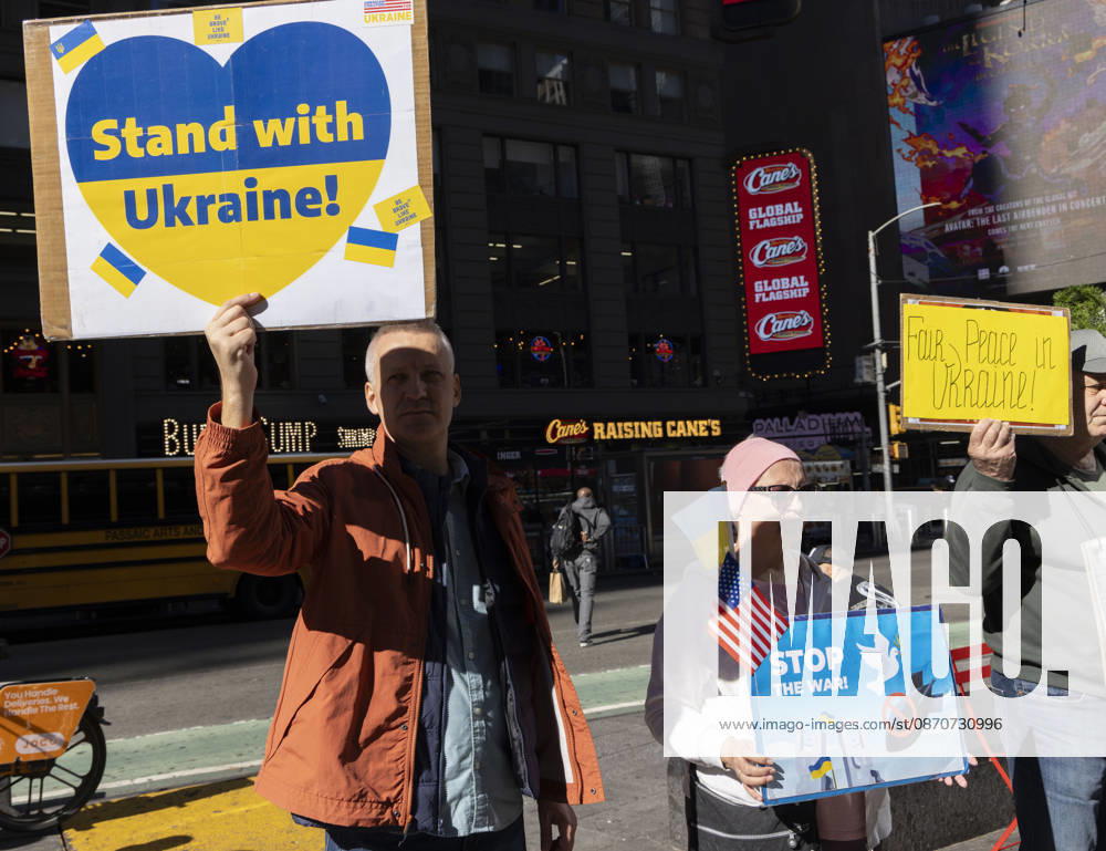 Demonstrators stand in Times Square holding Ukrainian and American flags and signs that read Stand with Ukraine! STOP THE WAR! Fair Peace in Ukraine! New York USA - ZUMAr174 20261025_znp_r174_029