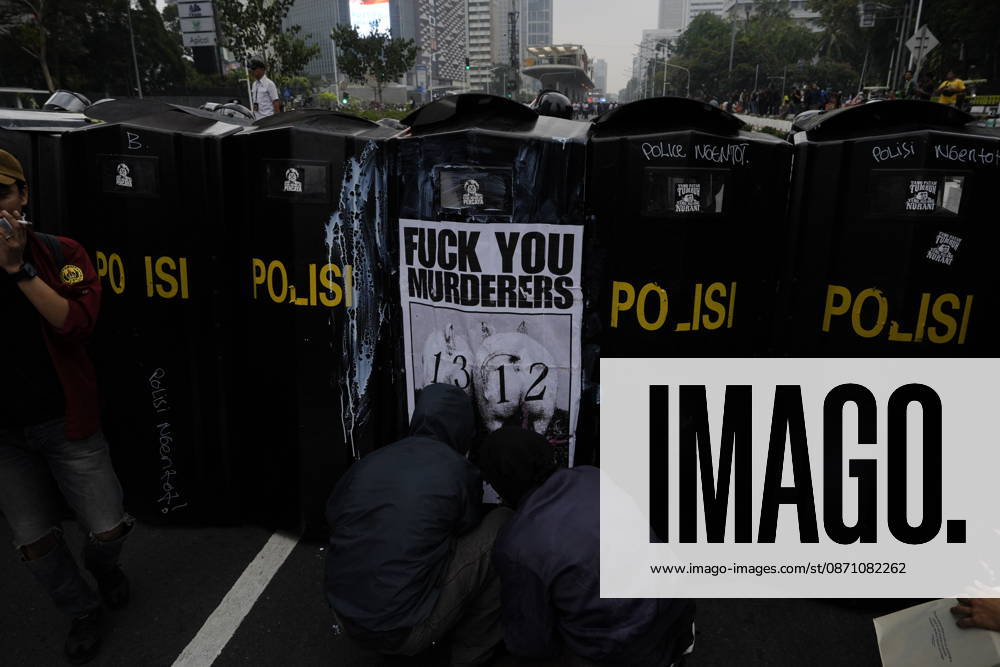 Student protesters crouch in front of police riot shields bearing a poster reading â€oeFuck You Murderers†during a demonstration at Bundaran HI Jakarta Indonesia - ZUMAm265 20261028_zip_m265_019