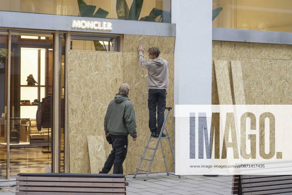 CNTV STORE PROTECTION: Storefronts and windows are boarded up with large wooden panels to protect them from looting. Workers are installing large wooden panels, particleboard, and barricades in front of stores. There is great fear of vandalism by demonstrators. October 31, 2026 Downtown Hamburg, Hamburg, Germany