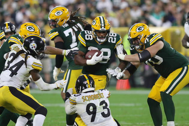 GREEN BAY, WI - OCTOBER 03: Green Bay Packers running back A.J. Dillon (28) runs through Pittsburgh Steelers inside linebacker Joe Schobert (93) during a game between the Green Bay Packers and the Pittsburgh Steelers at Lambeau Field on October 3, 2021 in Green Bay, WI. (Photo by Larry Radloff Icon Sportswire) NFL, American Football Herren, USA OCT 03 Steelers at Packers Icon2110034402