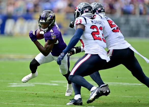 Baltimore Ravens wide receiver Zay Flowers (4) runs for short yardage against Houston Texans safety Eric Murray (23) and defensive end Jonathan Greenard (R) during the first half of the Baltimore Ravens home opener at M&T Bank Stadium in Baltimore, Maryland, on Sunday, September 10, 2023.  BAL20230910133 DAVIDxTULIS