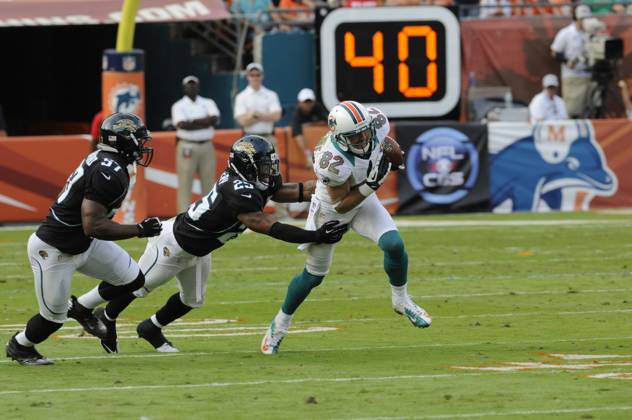 NFL, American Football Herren, USA Jaguars vs Dolphins DEC 16 December 16, 2012: Brian Hartline 82 of the Miami Dolphins tries to avoid the tackle by Dwight Lowery 25 of the Jacksonville Jaguars during the NFL football game between the Miami Dolphins and Jacksonville Jaguars at Sun Life Stadium in Miami Gardens FL. The Dolphins defeated the Jaguars 24-3. Miami Gardens FL U.S. EDITORIAL USE ONLY Copyright: xx ZUMA-20121216_zaf_cd5_106.jpg JCxRidleyx csmphoto689221
