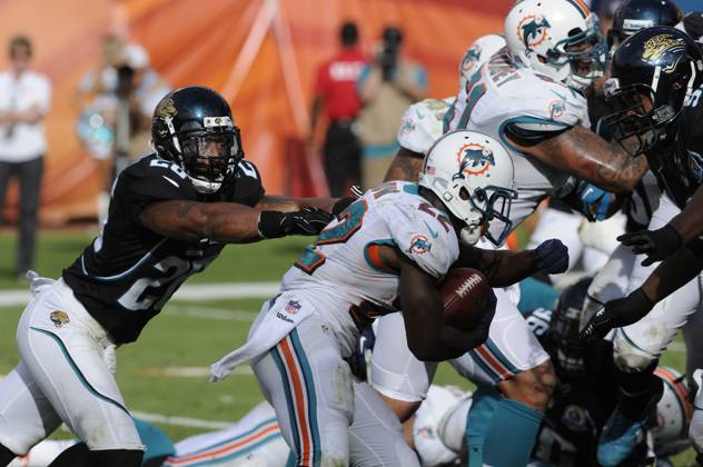 NFL, American Football Herren, USA Jaguars vs Dolphins DEC 16 December 16, 2012: Reggie Bush 22 of the Miami Dolphins tries to avoid the tackle by Dawan Landry 26 of the Jacksonville Jaguars during the NFL football game between the Miami Dolphins and Jacksonville Jaguars at Sun Life Stadium in Miami Gardens FL. The Dolphins defeated the Jaguars 24-3. Miami Gardens FL U.S. EDITORIAL USE ONLY Copyright: xx ZUMA-20121216_zaf_cd5_104.jpg JCxRidleyx csmphoto689223