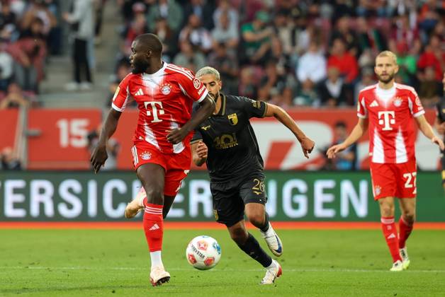 in duel, action, with Dayot Upamecano 2 FC Bayern Muenchen , Elias Saad 26 FC Augsburg , FC Augsburg vs FC Bayern Muenchen, Soccer, 1 Bundesliga, 2 Matchday, 30 08 2025 DFB regulations prohibit any use of photographs as image sequences and or quasi video Augsburg Bayern Germany Copyright: xkolbert-press ChristianxKolbertx