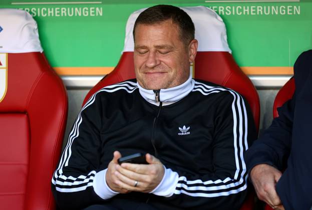 Football, Men, Season 2025 2026, FC Augsburg FC Bayern Munich, Bundesliga, WWK Arena Max Eberl, Chief Sports Officer FC Bayern Munich sitting on the trainers bench with a view of the cell phone, smartphone, phone, grinning, smiling DFL DFB regulations prohibit any use of photographs as image sequences and or quasi video