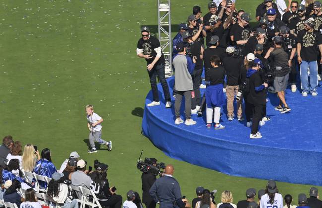 Los Angeles Dodgers first baseman Freddie Freeman (L) keeps an eye on his son Maximus as he celebrates their World Series win with teammates following a parade at Dodger Stadium in Los Angeles on Monday, November 3, 2025. LAP2025110316 JIMxRUYMEN