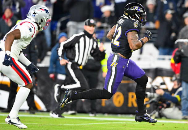 Baltimore Ravens running back Derrick Henry (22) runs past New England Patriots safety Jaylinn Hawkins (21) for a 21-yard touchdown run during the first quarter at M&T Bank Stadium in Baltimore, Maryland, on Sunday, December 21, 2025. BAL20251221111 DAVIDxTULIS