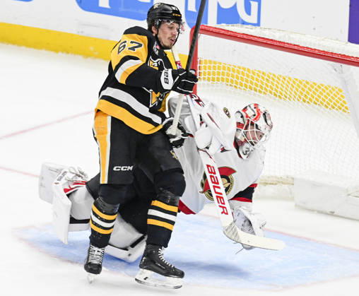 Pittsburgh Penguins right wing Rickard Rakell (67) receives a goalie Interference penalty as he collides with Ottawa Senators goaltender Linus Ullmark (35) during the first period at PPG Paints Arena in Pittsburgh on Monday, February 2, 2026.  PIT2026020204 ARCHIExCARPENTER