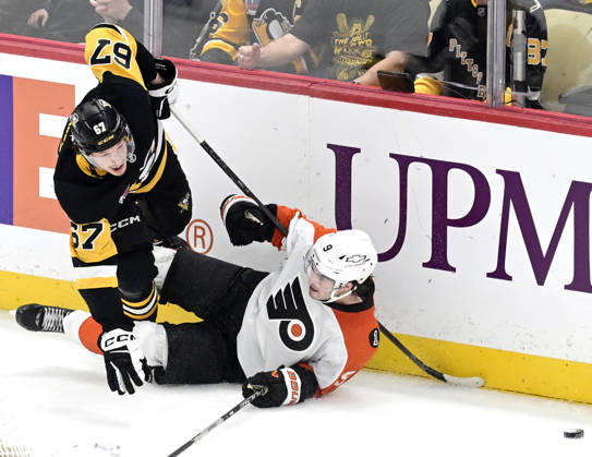 Pittsburgh Penguins right wing Rickard Rakell (67) and Philadelphia Flyers defenseman Jamie Drysdale (9) collide against the boards behind the goal during the overtime period of the 4-3 shootout win at PPG Paints Arena in Pittsburgh on Saturday, March 7, 2026.  PIT2026030719 ARCHIExCARPENTER