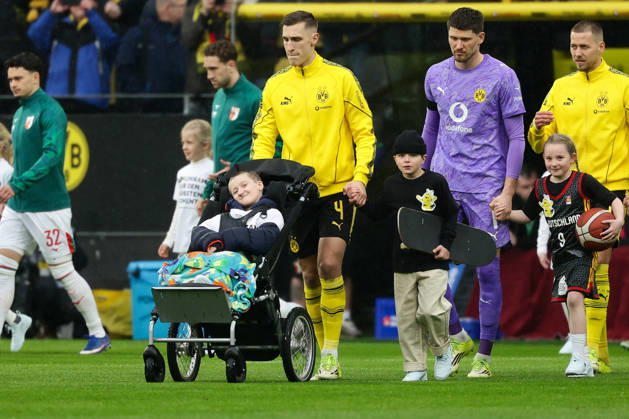 Dortmund, Germany, 14 03 26, Nico Schlotterbeck Borussia Dortmund with a child during the Bundesliga 1 match between Borussia Dortmund FC Augsburg at Signal Iduna Park in Dortmund Photo by Joachim Bywaletz DFB DFL REGULATIONS PROHIBIT ANY USE OF PHOTOGRAPHS AS IMAGE SEQUENCES AND OR QUASI VIDEO Copyright: JoachimxBywaletz xJB-Sportfoto
