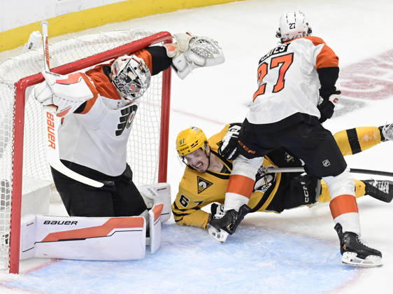 Pittsburgh Penguins right wing Rickard Rakell (67) falls to the ice as Pittsburgh Penguins defenseman Kris Letang shot finds the goal behind the skate of Philadelphia Flyers goaltender Dan Vladar (80) during the second period of the Pittsburgh Penguins 3-2 win in the opening round of the Eastern Conference playoffs at PPG Paints Arena in Pittsburgh on Monday, April 27, 2026.  PIT2026042715 ARCHIExCARPENTER