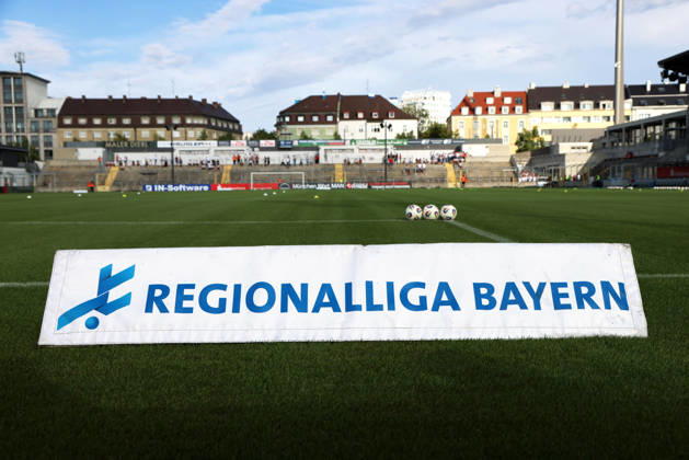 Soccer, Men s, Bavarian Regional League, 2026–2027 Season, TSV 1860 Munich vs. FC Augsburg II, Grünwalder Stadium Here is a foam banner featuring the Bavarian Regional League s lettering and logo, with the Grünwalder Stadium in the background