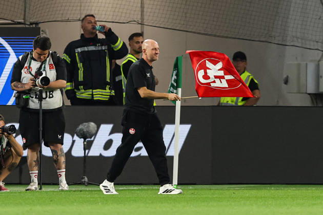 Coach Torsten Lieberknecht of 1. FC Kaiserslautern holding a 1. FC Kaiserslautern flag after the final whistle of the 2026–2027 Bundesliga match between VfL Wolfsburg and 1. FC Kaiserslautern at the Volkswagen Arena in Wolfsburg. Soccer, Man,Men, Germany, August 8, 2026