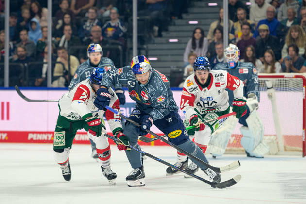 Hockey, DEL, 20261004, EHC Red Bull Munich vs. Augsburg Panthers. Pictured, from left: Alexander Blank (Augsburg, 26), Patrick Hager (Munich, 52), and D. J. Busdeker (Augsburg, 14). Munich SAP Garden, Bavaria, Germany Copyright: Passion2Press MarkusxFischerx