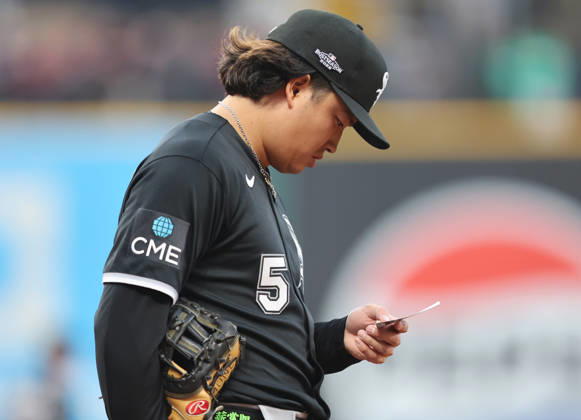 Chicago White Sox first baseman Munetaka Murakami (5) reads a slip of paper during the fourth inning against the Cleveland Guardians in an MLB, Baseball Herren, USA American League Division Series playoff game at Progressive Field in Cleveland, Ohio, on Monday, October 5, 2026.  CLE20261005716 AARONxJOSEFCZYK