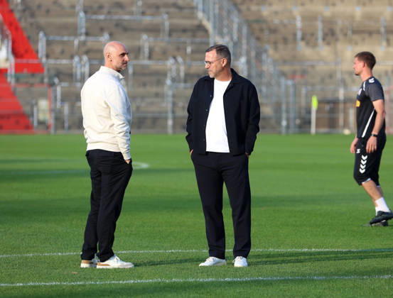 Soccer, Men s, Toto Cup, Quarterfinals, 2026–2027 Season, SpVgg Unterhaching vs. SSV Jahn Regensburg, Sportpark Unterhaching: Dr. Alexander Schmalhofer, sporting director of SSV Jahn Regensburg (left), and Sascha Hildmann, head coach of SSV Jahn Regensburg (right), standing on the field in conversation