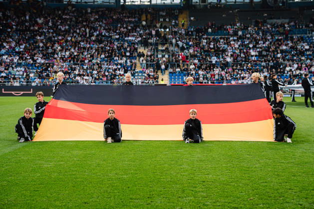 U-21 European Championship Qualifier: Germany vs. Georgia, October 6, 2026—German flag on the ground, held by children; soccer, U-21 European Championship Qualifier, Matchday 10: Germany vs. Georgia on October 6, 2026, Bielefeld DFB REGULATIONS PROHIBIT ANY USE OF PHOTOGRAPHS AS IMAGE SEQUENCES AND OR QUASI-VIDEO Copyright: xBEAUTIFULxSPORTS Tonhäuserx