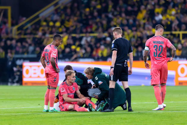 Dortmund, Germany, October 9, 2026, Bundesliga 1, 2026–2027, Matchday 5: Borussia Dortmund vs. SV Werder Bremen. Pictured: Amos Pieper (SVW) sits on the ground injured; from left: Arthur (SVW), Amos Pieper (SVW), referee Christian Dingert, Marco Friedl (SVW). DFL and DFB regulations prohibit any use of photographs as image sequences and or quasi-video. Signal Iduna Park, North Rhine-Westphalia Copyright: xFotostandx xZeisingx