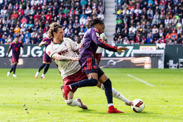 Germany: FC Augsburg vs. FC Bayern Munich, Bundesliga 1, Matchday 5, 2026–27 Season, WWK Arena, Augsburg. Calvin Brackelmann (FC Augsburg, No. 2) in a tackle with Michael Olise (FC Bayern Munich, No. 17). Augsburg, WWK Arena, Bayern, Germany Copyright: xBenedictxChristx
