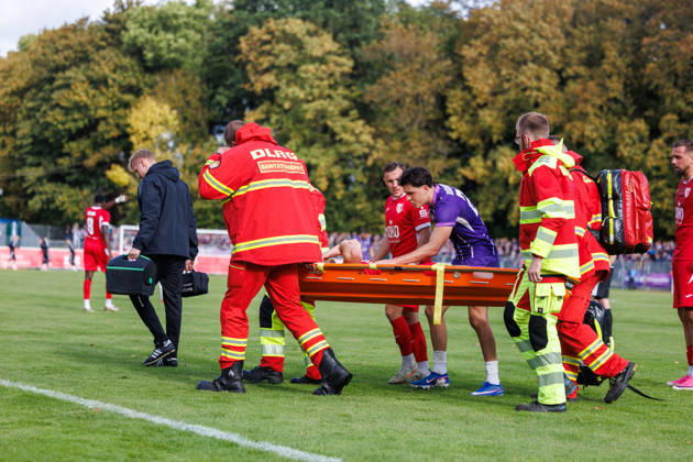 Janis Juckel of Greifswald has to be carried off the field on a stretcher after being injured. In the middle, Maxim Burghardt of Aue apologizes. GER, Greifswalder FC vs. FC Erzgebirge Aue, Soccer, Men, Northeast Regional League, Matchday 12, 2026–2027 season, October 11, 2026, Greifswald Volksstadion, Mecklenburg-Western Pomerania, Germany