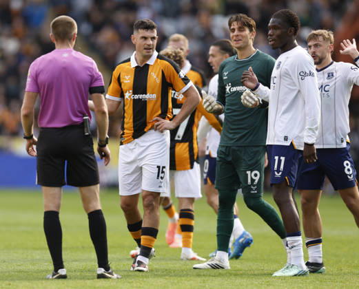 Kingston upon Hull, England, 11th October 2026. Referee Michael Salisbury waits with John Egan of Hull City as the Everton players complain during the Hull City vs Everton Premier League match at the MKM Stadium, Kingston upon Hull. Picture credit should read: Cody Froggatt Sportimage EDITORIAL USE ONLY. No use with unauthorised audio, video, data, fixture lists, club league logos or live services. Online in-match use limited to 120 images, no video emulation. No use in betting, games or single club league player publications. SPI_028_CF_HULL_CITY_EVERTON SPI-5062-0029