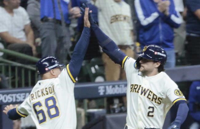 Milwaukee Brewers Brice Turang (2) celebrates with third base coach Matt Erickson after hitting a solo home run against the Los Angeles Dodgers in the fourth inning of an MLB, Baseball Herren, USA National League Championship Series playoff game at American Family Field in Milwaukee, Wisconsin, on Sunday, October 11, 2026.  MIL20261011713 TANNENxMAURY