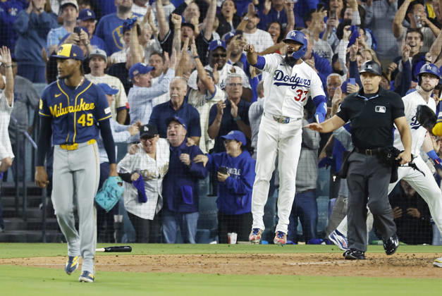 Los Angeles Dodger Teoscar Hernandez (37) celebrates as Milwaukee Brewers pitcher Abner Uribe (45) reacts after scoring on a two-rbi double by Will Smith in the sixth inning of the MLB, Baseball Herren, USA National League Championship Series playoffs at Dodger Stadium in Los Angeles, California, on Wednesday, October 14, 2026.  LAP20261014722 CAROLINExBREHMAN