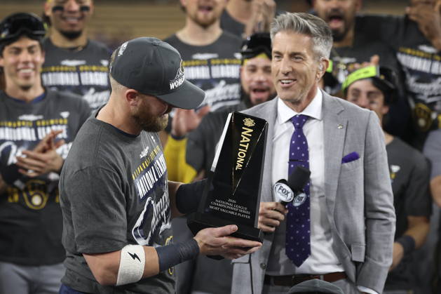 MLB, Baseball Herren, USA Postseason: NLCS Game 4 - Los Angeles Dodgers vs Milwaukee Brewers Milwaukee Brewers first baseman Jake Bauers (L) is presented with the Most Valuable Player trophy after winning Game 4 of the National League Championship Series against the Los Angeles Dodgers at Dodger Stadium in Los Angeles, California, USA, 15 October 2026. LOS ANGELES CALIFORNIA UNITED STATES Copyright: xCHRISxTORRESx