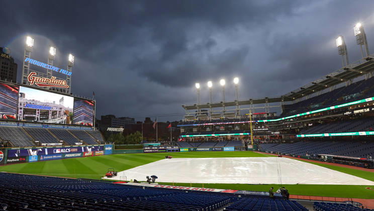 A tarp covers the infield as rain falls before the start of game four of the MLB, Baseball Herren, USA American League Championship Series between the Tampa Bay Rays and the Cleveland Guardians at Progressive Field in Cleveland, Ohio, on Friday, October 16, 2026. The 8pm ET start of the game has been delayed due to the weather.  CLE20261016704 AARONxJOSEFCZYK