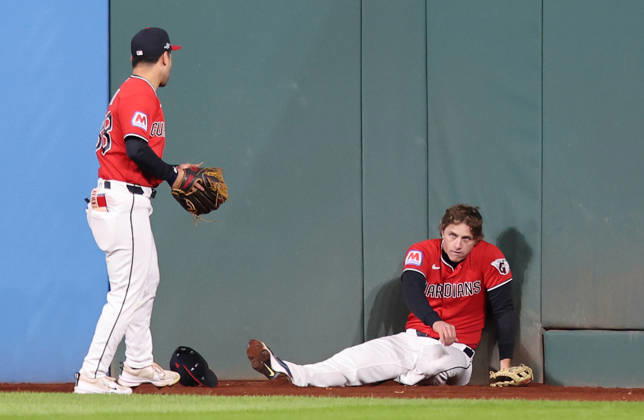 Cleveland Guardians center fielder Petey Halpin (R) sits on the ground after going up against the wall to catch a long fly ball from Tampa Bay Rays Junior Caminero as left fielder Steven Kwan (38) assists in the fourth inning during game four of the MLB, Baseball Herren, USA American League Championship Series at Progressive Field in Cleveland, Ohio, on Saturday, October 17, 2026.  CLE20261017714 AARONxJOSEFCZYK