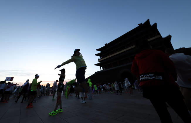 (261018) -- BEIJING, Oct. 18, 2026 -- Runners pose for photos before the 2026 Beijing Marathon & National Marathon Championships in Beijing, capital of China, Oct. 18, 2026. ) (SP)CHINA-BEIJING-2026 BEIJING MARATHON(CN) LixMing 
