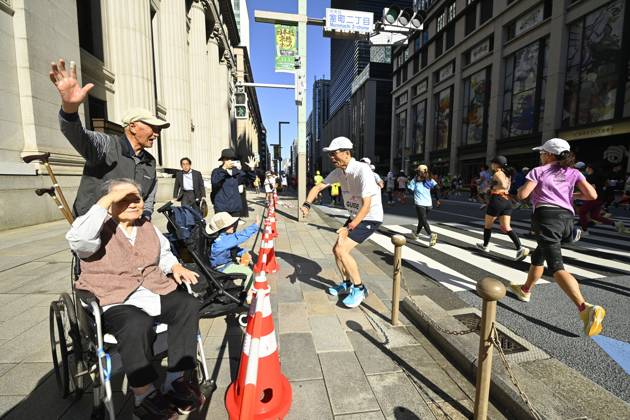 Runners take part in Tokyo Half Marathon in Japan TOKYO, JAPAN - OCTOBER 18 : A runner high-fives a young boy sitting in a stroller as a person in a wheelchair watches participants pass during the Tokyo Half Marathon in the Muromachi district of Tokyo, Japan, October 18, 2026. David Mareuil Anadolu Tokyo Japan. Editorial use only. Please get in touch for any other usage.  Copyright: x2026xAnadoluxDavidxMareuilx