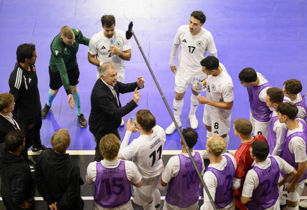 National team coach Marcel Loosveld (GER) gives instructions during a timeout, gesturing, surrounded by players during the Futsal World Cup qualifying match between Germany and Lithuania (4–2) on October 18, 2026, at the Westenergie Sporthalle in Mülheim an der Ruhr, Germany