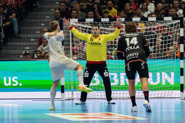 Kassel, Germany, October 22, 2026 EHF Champions League 2026–2027 Group Stage Group B Match 5 MT Melsungen vs. Orlen Wisla Plock Pictured from left: Frederik Bjerre (SPR) in a duel and goalkeeper Nebojöa Simic Nebojsa Simic (MT) during a seven-meter throw at Rothenbach Hall, Hesse Copyright: xFotostandx xKruczynskix