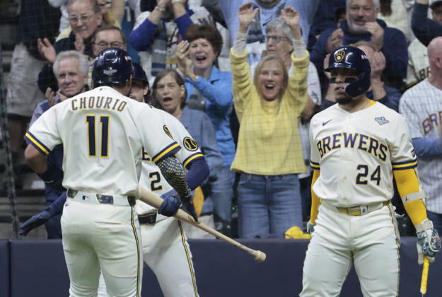 Milwaukee Brewers Jackson Chourio (11) is congratulated by teammates after scoring on a triple by designated hitter Christian Yelich against the Tampa Bay Rays in the first inning during game one of the 2026 MLB, Baseball Herren, USA World Series at American Family Field in Milwaukee, Wisconsin, on Friday, October 23, 2026.  MIL20261023709 TANNENxMAURY
