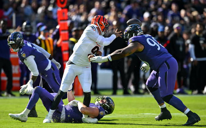 Cincinnati Bengals quarterback Joe Burrow (9) is stopped for no gain by Baltimore Ravens linebacker Ethan Burke (97) and defensive lineman Travis Jones (98) during the first quarter at M&T Bank Stadium in Baltimore, Maryland, on Sunday, October 25, 2026.  BAL20261025106 DAVIDxTULIS