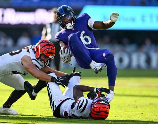 Baltimore Ravens running back Rasheen Ali (26) is tripped up by Cincinnati Bengals linebacker Jack Kiser (L) and cornerback Josh Newton (C) during a first down in the fourth quarter at M&T Bank Stadium in Baltimore, Maryland, on Sunday, October 25, 2026. Cincinnati won 35-13.  BAL20261025112 DAVIDxTULIS