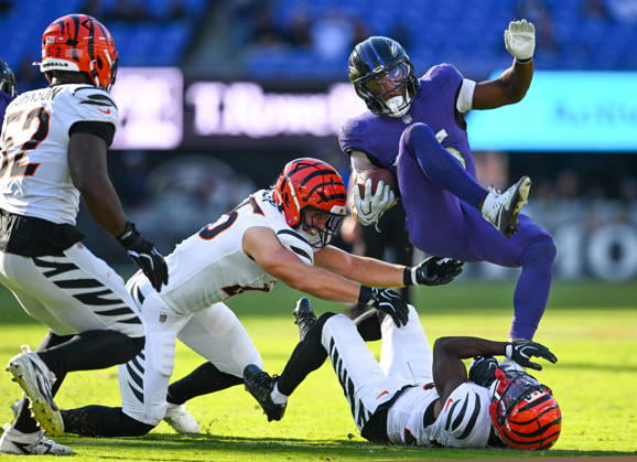 Baltimore Ravens running back Rasheen Ali (26) is tripped up by Cincinnati Bengals linebacker Jack Kiser (L) and cornerback Josh Newton (C) while defensive end Cedric Johnson (52) backs up during a first down in the fourth quarter at M&T Bank Stadium in Baltimore, Maryland, on Sunday, October 25, 2026. Cincinnati won 35-13.  BAL20261025116 DAVIDxTULIS