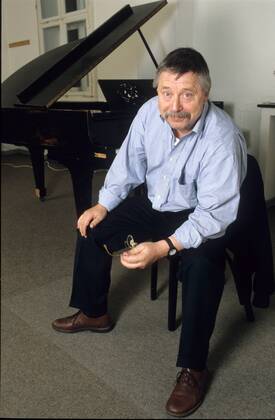 Wolf Biermann (Liedermacher, Autor) 11 99 thg Mann Musik Liedermacher Gesang Autor Schriftstellerei Literatur Buch Brille Schnäuzer leger Hemd sitzend aufstützend haltend Piano Klavier Instrument ganz hoch lächelnd