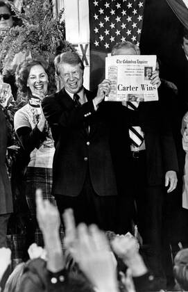 Nov. 3, 1976 - President Elect Jimmy Carter holds up a newspaper declaring Carter Wins as its headline the morning after the 1976 General Election. Carter, fariends, family and supporters jammed the streets around the railway depot in Carter s hometown of Plains, Ga. - ZUMAkh1_
