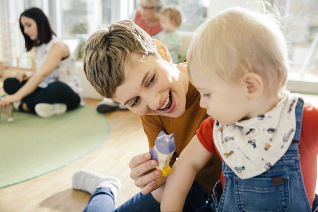 Pre-school teacher playing with toddler in kindergarten model released Symbolfoto property released  MFF04068
