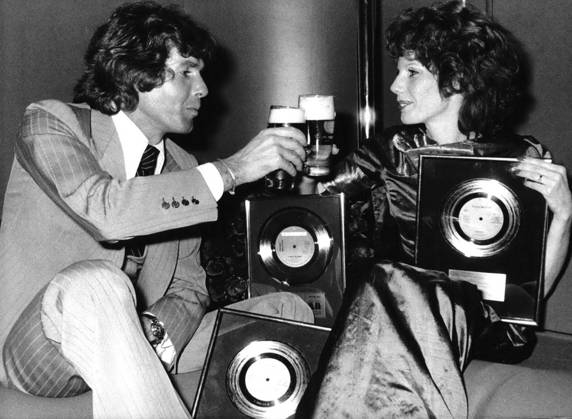 Bands Komponisten Instrumente Musiker Oper Orchester Schallplatten Sänger Songwriter Symphonien 12. Dezember 1973 Drei Goldene Schallplatten für Penny McLean: Prost Sänger Chris Roberts stößt mit Penny McLean an, um ihren dreifachen Goldenen Schallplatten-Erfolg zu feiern. Penny McLean, geboren in Österreich und aufgewachsen in Bayern, erhielt die Goldenen Schallplatten für ihren Hit Lady Bump, von dem sich in Westdeutschland 700.000 Singles, in den Benelux-Ländern 100.000 und in Kanada über 75.000 verkauften. Die erfolgreiche Vertreterin des Sound of Munich ist auch Mitglied der Gruppe Silver Convention, die mit Fly Robin Fly einen Hit landete. London England United Ki  Copyright: xUnitedxArchivesx xkpaxKeystonex 19600101_p01_k09_283 !ACHTUNG AUFNAHMEDATUM GESCHÄTZT!