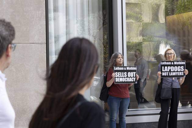 October 7, 2025, New York, New York, USA: Demonstrators with the activist group Rise and Resist hold signs that read Latham and Watkins SELLS OUT DEMOCRACY Latham and Watkins LAPDOGS NOT LAWYERS outside of the offices of Latham and Watkins LLP in midtown Manhattan as lunchtime crowds pass. Protesters stage a peaceful demonstration denouncing the law firm s agreement to provide millions in pro bono legal work to initiatives from President Trumpâ€⠢s agenda and to abandon diversity, equity, and inclusion (DEI) policies. New York USA - ZUMAr174 20251007_znp_r174_034 Copyright: xGinaxMxRandazzox