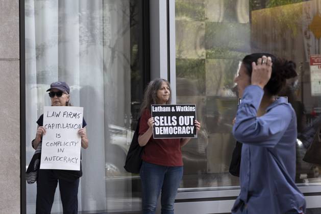 October 7, 2025, New York, New York, USA: Demonstrators with the activist group Rise and Resist hold signs that read LAW FIRMS CAPITULATION IS COMPLICITY IN AUTOCRACY Latham and Watkins SELLS OUT DEMOCRACY outside of the offices of Latham and Watkins LLP in midtown Manhattan as lunchtime crowds pass. Protesters stage a peaceful demonstration denouncing the law firm s agreement to provide millions in pro bono legal work to initiatives from President Trumpâ€⠢s agenda and to abandon diversity, equity, and inclusion (DEI) policies. New York USA - ZUMAr174 20251007_znp_r174_035 Copyright: xGinaxMxRandazzox